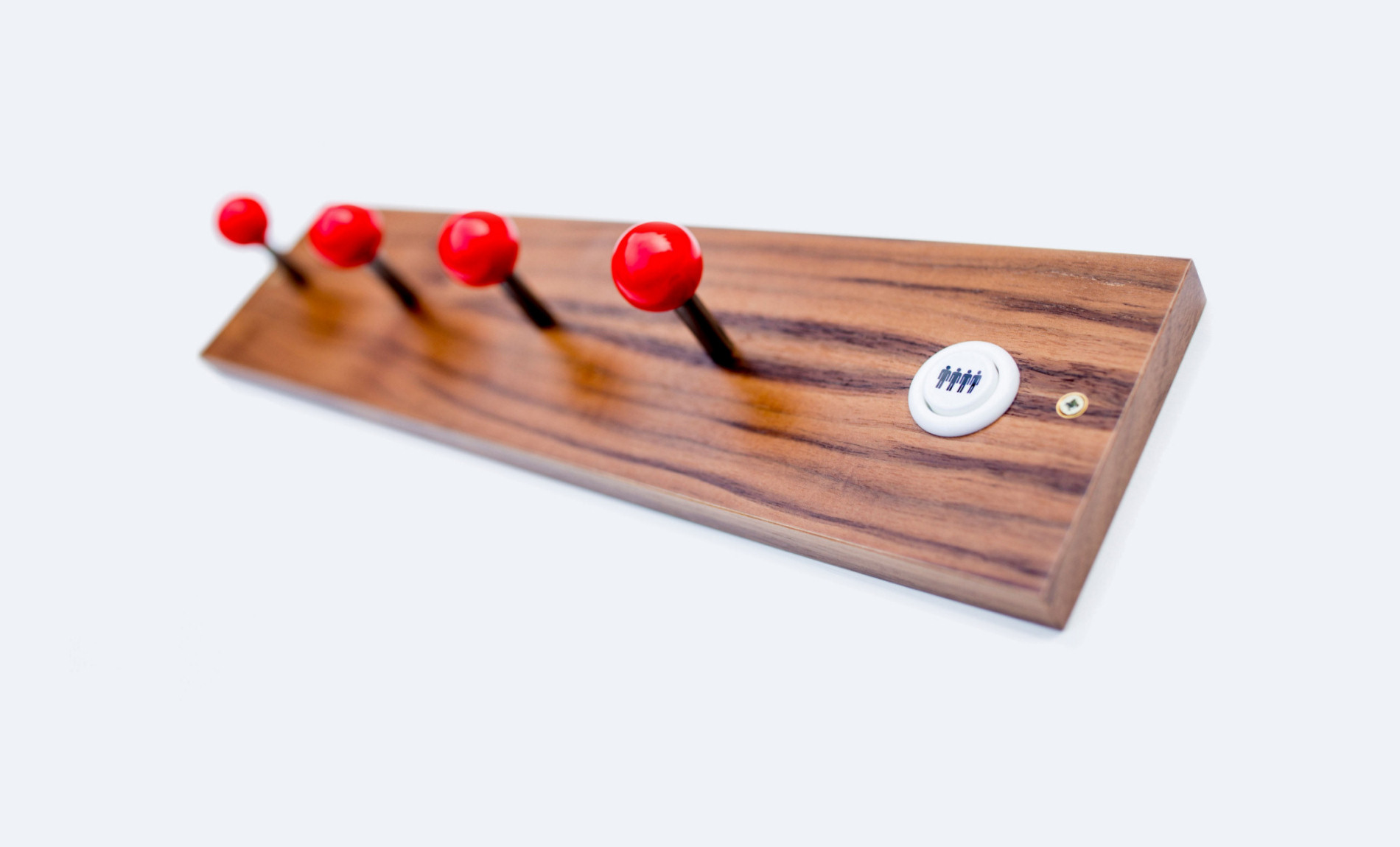 arcade coat hooks with red joysticks on walnut panel